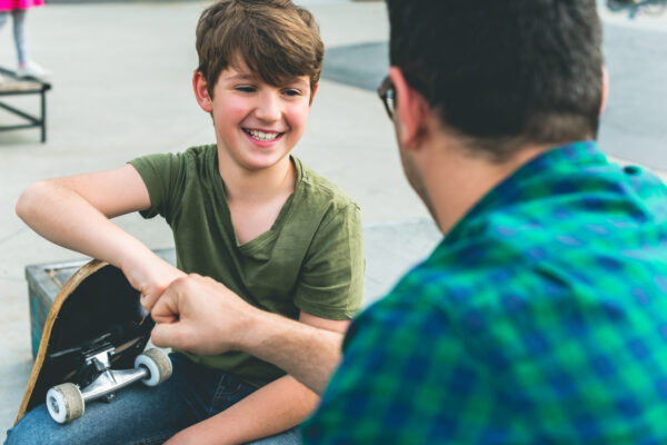 Jongen met skateboard en man
